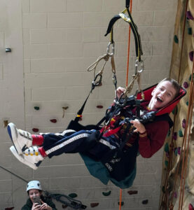 Boy with MLD at Bendrigg Trust on climbing wall